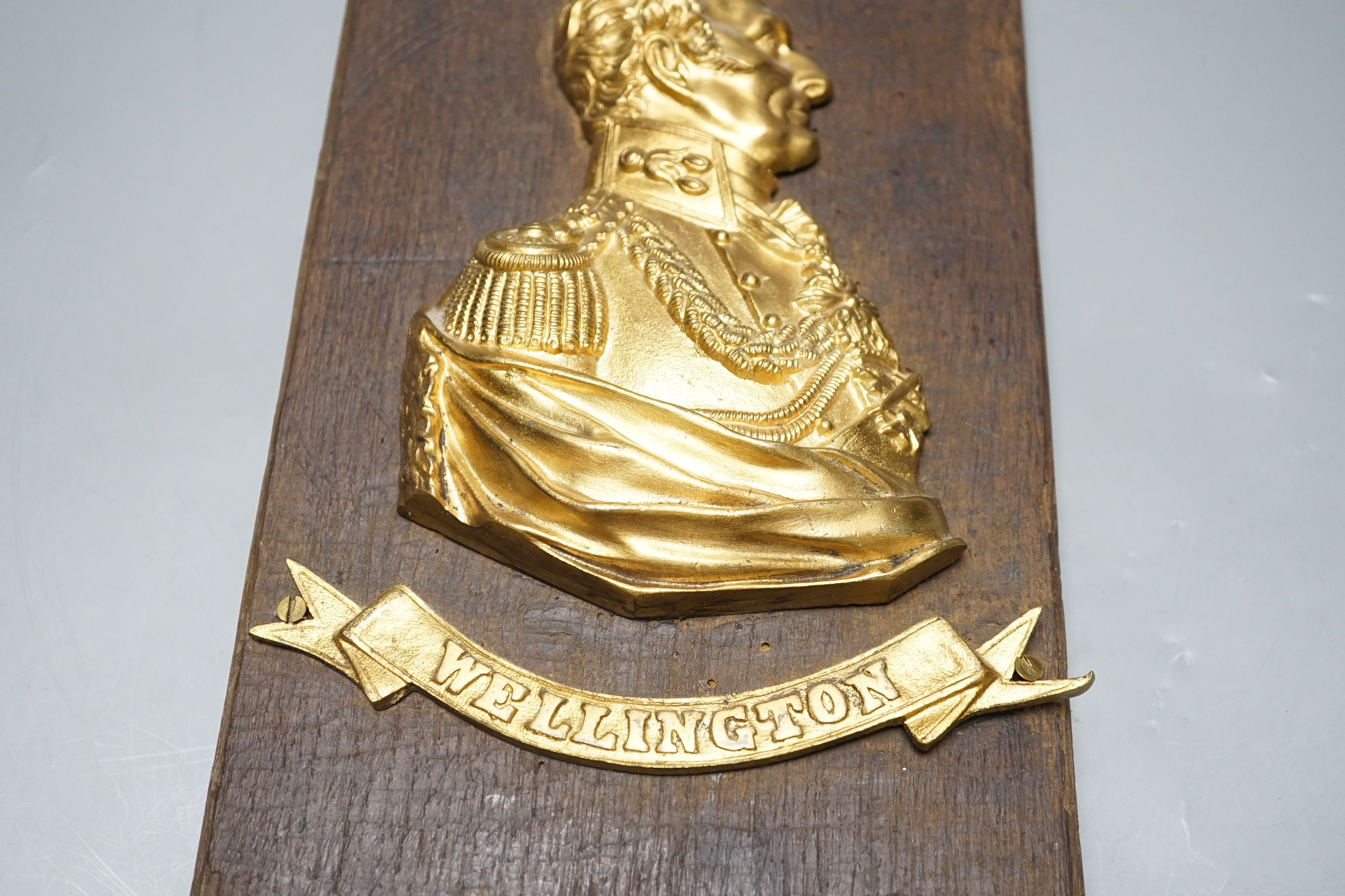 A gilt metal ‘Wellington’ plaque on wooden panel, 30 x 19cm